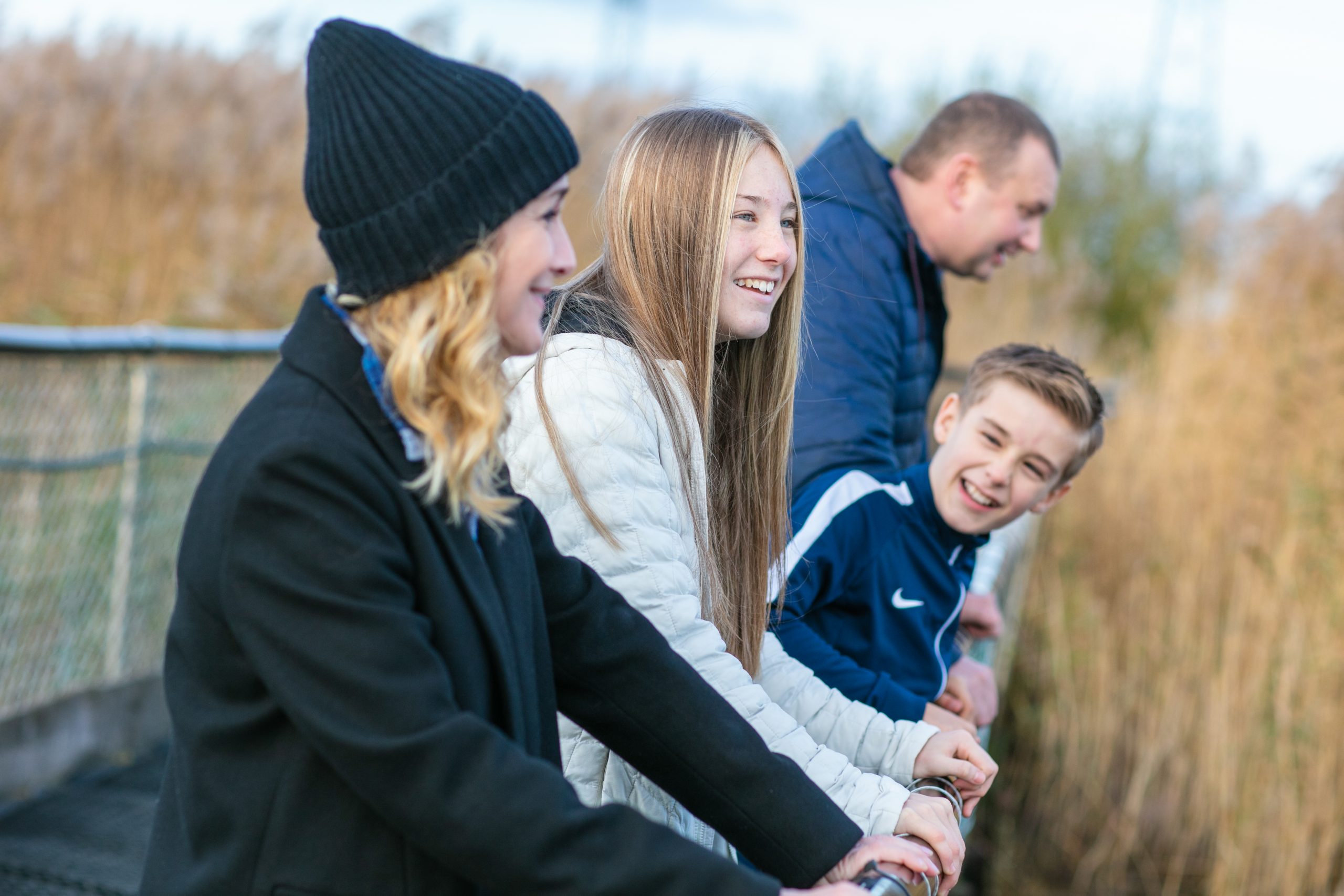 family peering off a bridge laughing